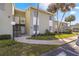 Exterior view of a light-green building with stairs and palm trees at 551 Fairways Dr # A, Ocala, FL 34472