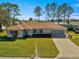 Aerial view of single-story home with a two-car garage and well maintained lawn at 8475 Se 137Th Loop, Summerfield, FL 34491