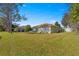 Large backyard with grassy area, providing ample space for outdoor activities at 8475 Se 137Th Loop, Summerfield, FL 34491