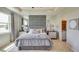 Spacious main bedroom with gray upholstered bed and en-suite bathroom at 4737 Nw 39Th Street Rd, Ocala, FL 34482