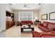 Bright living room with leather sofas, a large window, and a ceiling fan at 7819 Se 12Th Cir, Ocala, FL 34480