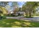 Gray house with brick driveway, lush landscaping, and mature trees at 7819 Se 12Th Cir, Ocala, FL 34480