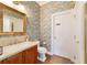 Small bathroom with world map wallpaper and wood vanity at 7819 Se 12Th Cir, Ocala, FL 34480