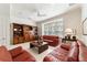 Spacious living room featuring leather sofas, built-in shelving, and a large window at 7819 Se 12Th Cir, Ocala, FL 34480
