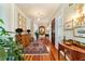 Long hallway with hardwood floors, antique furniture and gallery wall at 7819 Se 12Th Cir, Ocala, FL 34480