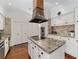 White kitchen with granite countertops, large island, and a statement hood at 1218 Se 11Th St, Ocala, FL 34471