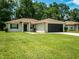 One-story house with a beige exterior, brown roof, and a two-car garage at 5400 Nw 55Th Pl, Ocala, FL 34482