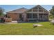Attractive house back elevation showcasing a large sunroom and well-maintained lawn at 13166 Se 86Th Cir, Summerfield, FL 34491