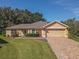House exterior with a driveway and landscaping at 13166 Se 86Th Cir, Summerfield, FL 34491