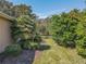 Landscaped backyard with lush greenery and a paved walkway at 13166 Se 86Th Cir, Summerfield, FL 34491