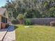 Large backyard with a grassy area, wooden fence, and bird feeders at 13166 Se 86Th Cir, Summerfield, FL 34491