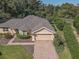 Aerial view of a single-story house with a paved driveway and landscaped yard at 13166 Se 86Th Cir, Summerfield, FL 34491