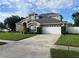 Brick house with two-car garage, and landscaped lawn at 3403 Gatlin Place Cir, Orlando, FL 32812