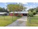Red house with metal roof, driveway, and fenced yard at 2810 Se 8Th St, Ocala, FL 34471