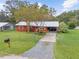 Red brick ranch home with metal roof, driveway, and fenced yard at 2810 Se 8Th St, Ocala, FL 34471