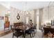 Bright dining room with a wood table and chandelier, offering a view to the kitchen at 2210 Se Laurel Run Dr, Ocala, FL 34471