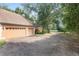 Two-car garage with paver driveway and mature landscaping at 2210 Se Laurel Run Dr, Ocala, FL 34471