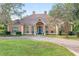 Tan two-story house with a double door entry and manicured lawn at 2210 Se Laurel Run Dr, Ocala, FL 34471