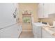 Bright laundry room with washer, dryer, and built-in cabinets at 2210 Se Laurel Run Dr, Ocala, FL 34471