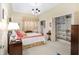 Bright bedroom with coral bedding, walk-in closet, and built-in shelving at 2210 Se Laurel Run Dr, Ocala, FL 34471