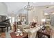 Open living space with a piano, chandelier, and views into the kitchen and dining area at 2210 Se Laurel Run Dr, Ocala, FL 34471