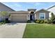 Two-car garage and front yard landscaping highlight this home's exterior at 5584 Sw 43Rd Ct, Ocala, FL 34474