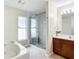 Luxurious bathroom with a large walk-in shower and a soaking tub at 8335 Se 162Nd Pl, Summerfield, FL 34491