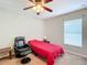 Bright bedroom with a comfortable chair and a red bed at 8335 Se 162Nd Pl, Summerfield, FL 34491