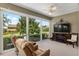 Sunroom with fireplace, TV, and relaxing seating at 11703 Se 91St Cir, Summerfield, FL 34491