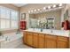 Bathroom boasts double sinks, garden tub, and large mirror at 11703 Se 91St Cir, Summerfield, FL 34491