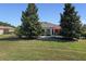 Landscaped backyard with lush lawn and mature trees at 11703 Se 91St Cir, Summerfield, FL 34491