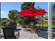 Brick patio with red umbrella, grill, and seating at 11703 Se 91St Cir, Summerfield, FL 34491