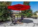 Relaxing patio with table, chairs, and red umbrella at 11703 Se 91St Cir, Summerfield, FL 34491