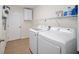 Bright laundry room with washer, dryer, and storage shelves at 14185 Sw 30Th Pl, Ocala, FL 34481