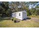 White storage shed with a roll-up door and window at 14185 Sw 30Th Pl, Ocala, FL 34481