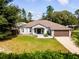 House with a brown garage door and a landscaped yard at 12805 Sw 64Th Ln, Ocala, FL 34481