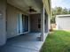 Covered patio with ceiling fan, sliding glass doors, and grassy backyard at 12805 Sw 64Th Ln, Ocala, FL 34481