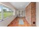 Sunroom features terracotta tile floors, brick wall, and access to backyard at 34241 S Haines Creek Rd, Leesburg, FL 34788