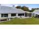 Rear view of house showcasing a large yard and screened patio at 6042 Topsail Rd, Lady Lake, FL 32159
