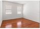 Simple bedroom with hardwood floors and two windows with blinds at 6175 Sw 88Th Loop, Ocala, FL 34476