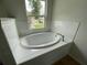 Oval soaking tub with tile surround in bright bathroom at 4503 Sw 132Nd St, Ocala, FL 34473