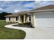 Tan house with white garage door and landscaping at 4503 Sw 132Nd St, Ocala, FL 34473