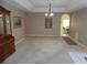 Bright dining room with neutral walls and carpet, featuring a chandelier and built-in hutch at 10970 Sw 69Th Cir, Ocala, FL 34476