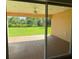 View of backyard through sliding glass doors leading to covered patio at 2030 Sw 163Rd Pl, Ocala, FL 34473