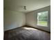 Bright bedroom with carpet flooring and a window offering a view of the backyard at 2030 Sw 163Rd Pl, Ocala, FL 34473