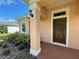 Inviting house exterior with a peach-colored facade, brown door, and landscaping at 2030 Sw 163Rd Pl, Ocala, FL 34473