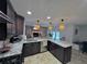 L-shaped kitchen with granite island and stone fireplace views at 730 Ne 18Th Ave, Ocala, FL 34470