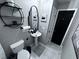 Small bathroom with pedestal sink, toilet, and black accents at 730 Ne 18Th Ave, Ocala, FL 34470