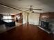Open living room and kitchen with stone fireplace and hardwood floors at 8685 Sw 67 Ct, Ocala, FL 34476