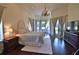 Main bedroom with hardwood floors, a luxurious bed, and access to a patio at 1525 Se 59Th St, Ocala, FL 34480